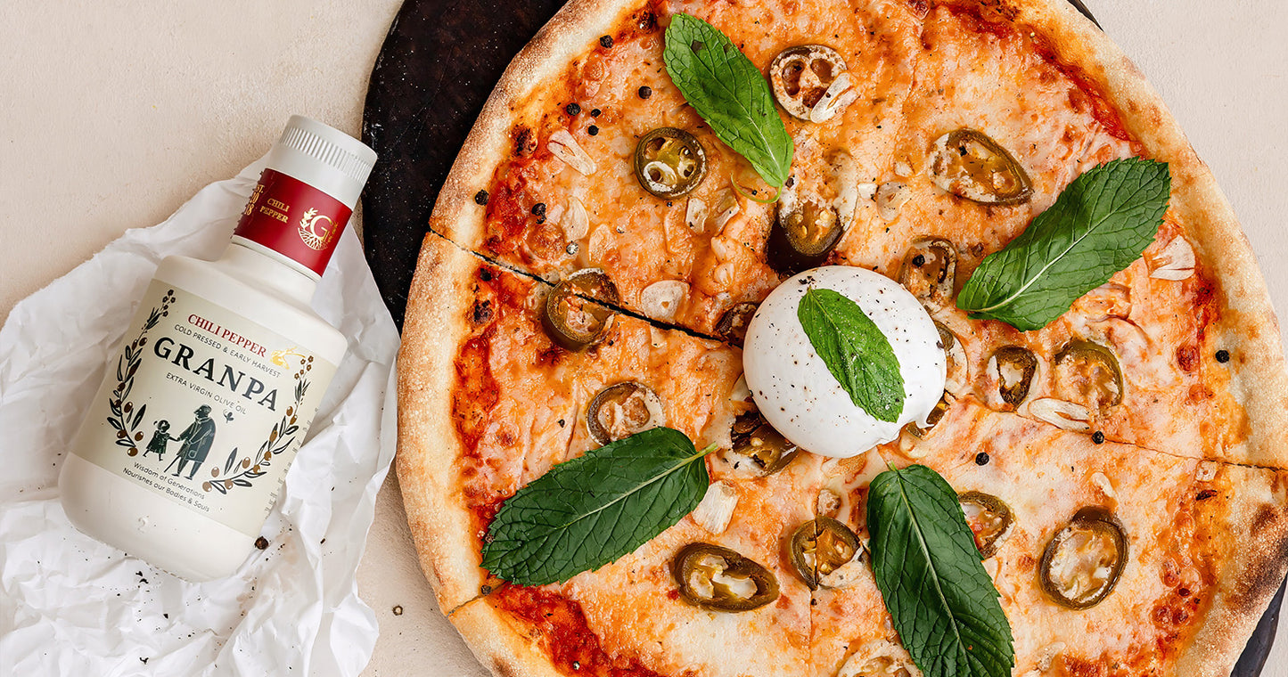 Granpa acı biberli çeşnili zeytinyağı ile hazırlanmış pizzanın yanında ürün şişesi – aromalı natürel sızma zeytinyağı