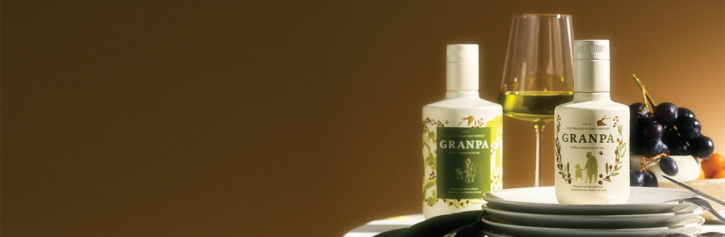 Granpa natürel sızma zeytinyağı şişeleri ve üzüm eşliğinde sofrada premium sunum – soğuk sıkım, yüksek polifenol özel seri